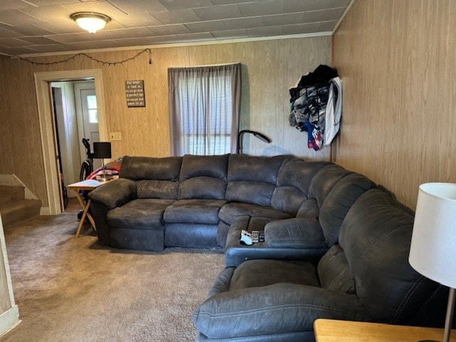 carpeted living room featuring wooden walls