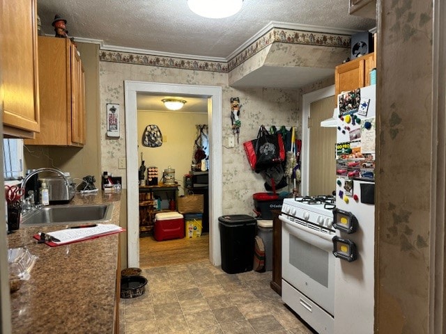 kitchen with white appliances, sink, and a textured ceiling