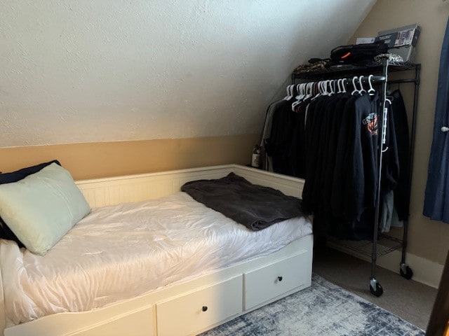 bedroom featuring vaulted ceiling and carpet flooring