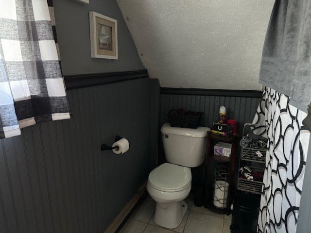 bathroom featuring toilet, tile patterned floors, and a textured ceiling