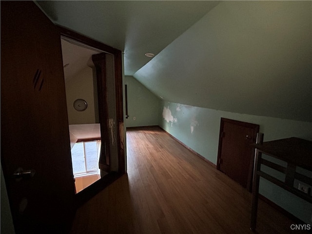 additional living space featuring hardwood / wood-style flooring and vaulted ceiling