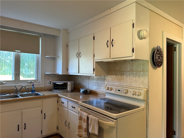 kitchen with white cabinetry, tasteful backsplash, white electric range oven, and sink