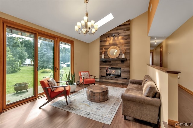 living room with wooden walls, hardwood / wood-style floors, a chandelier, high vaulted ceiling, and a multi sided fireplace