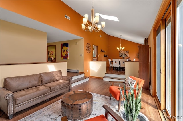 living room featuring hardwood / wood-style floors, baseboard heating, an inviting chandelier, and lofted ceiling with skylight