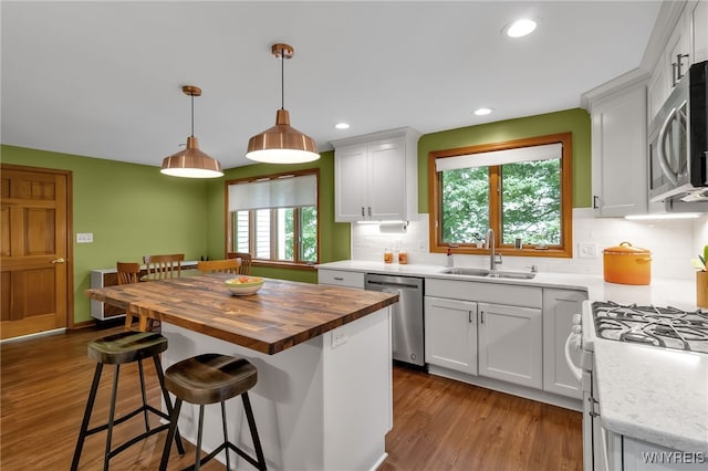 kitchen featuring appliances with stainless steel finishes, sink, white cabinetry, butcher block counters, and light wood-type flooring