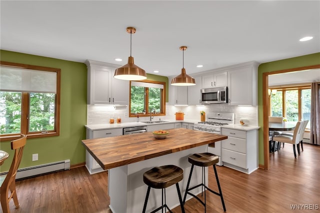 kitchen with plenty of natural light, a breakfast bar, appliances with stainless steel finishes, and white cabinetry