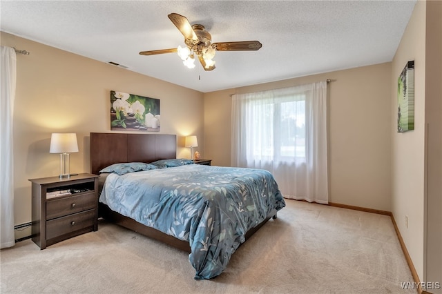 carpeted bedroom with a textured ceiling, baseboard heating, and ceiling fan