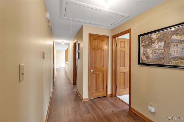 hall featuring a textured ceiling and light hardwood / wood-style flooring