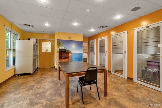 dining area featuring a drop ceiling