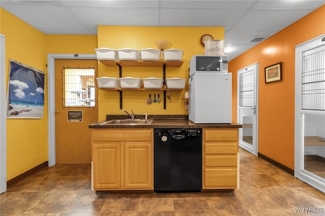 kitchen featuring black dishwasher, sink, light brown cabinets, and a drop ceiling