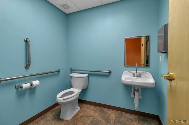 bathroom featuring toilet, a paneled ceiling, and sink