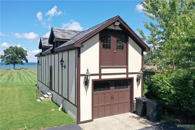 view of home's exterior featuring a garage, a yard, and a water view