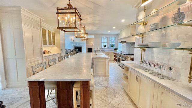 kitchen with a center island with sink, a kitchen breakfast bar, and pendant lighting