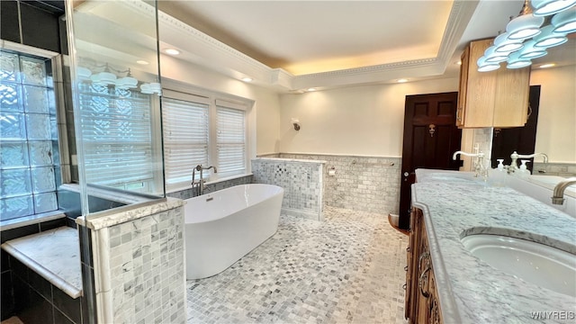 bathroom with tile patterned flooring, vanity, a tub to relax in, and a tray ceiling