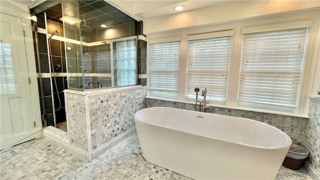 bathroom with tile patterned flooring, tile walls, and shower with separate bathtub