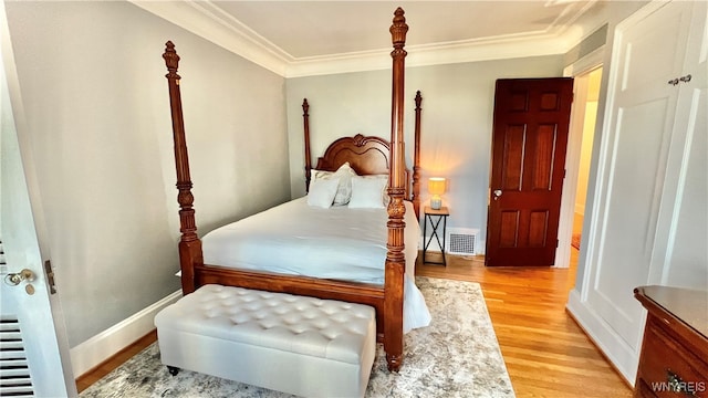 bedroom with light wood-type flooring and crown molding