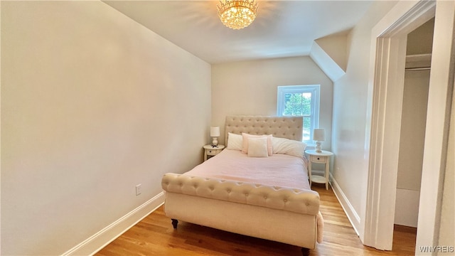 bedroom with wood-type flooring and a chandelier