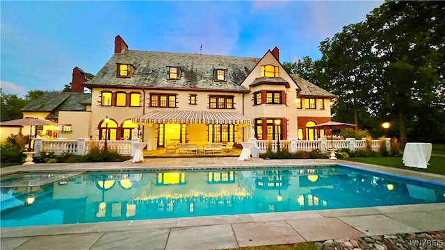 back house at dusk featuring an outdoor living space and a patio