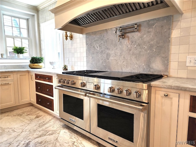 kitchen with decorative backsplash, range with two ovens, custom range hood, and crown molding