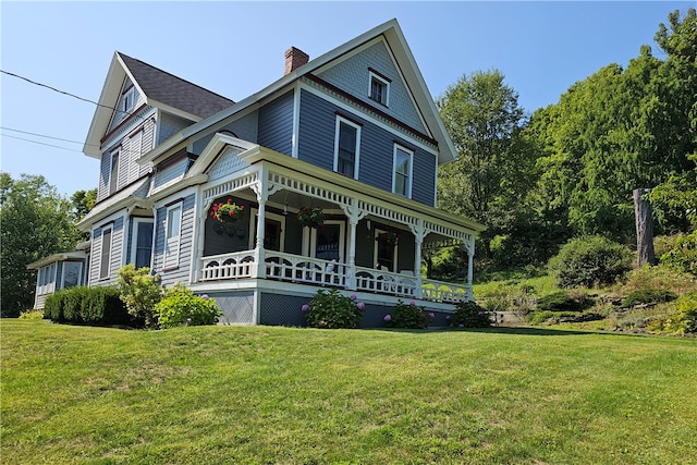 victorian house featuring a front lawn and covered porch