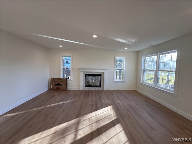 unfurnished living room featuring wood-type flooring and a fireplace