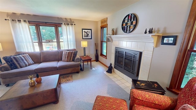 carpeted living room with a tile fireplace