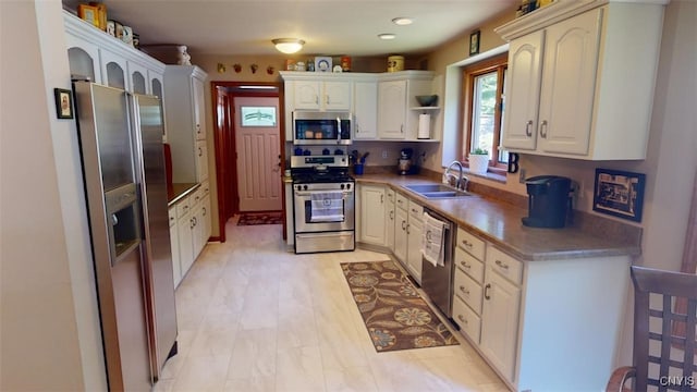 kitchen featuring stainless steel appliances, sink, and white cabinets