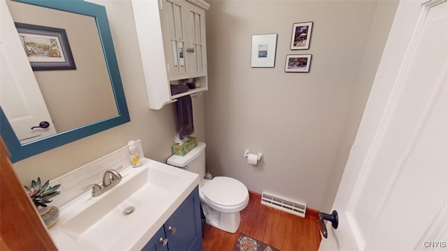 bathroom with vanity, toilet, and hardwood / wood-style floors