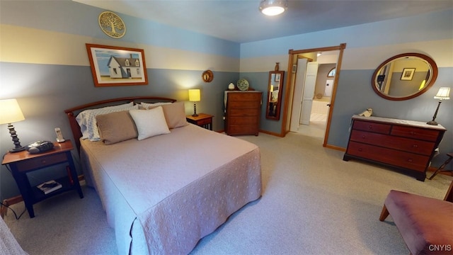 bedroom featuring light colored carpet and ensuite bath