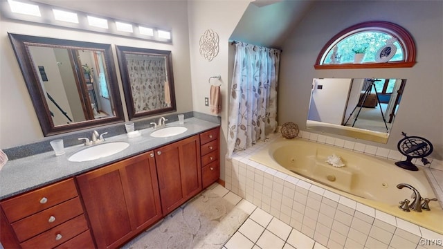 bathroom featuring tile patterned flooring, tiled tub, and vanity