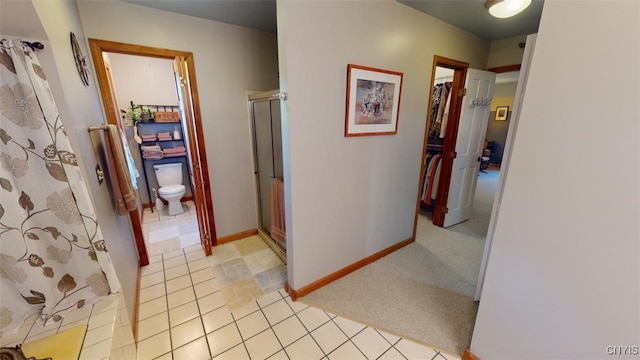 corridor featuring light colored carpet