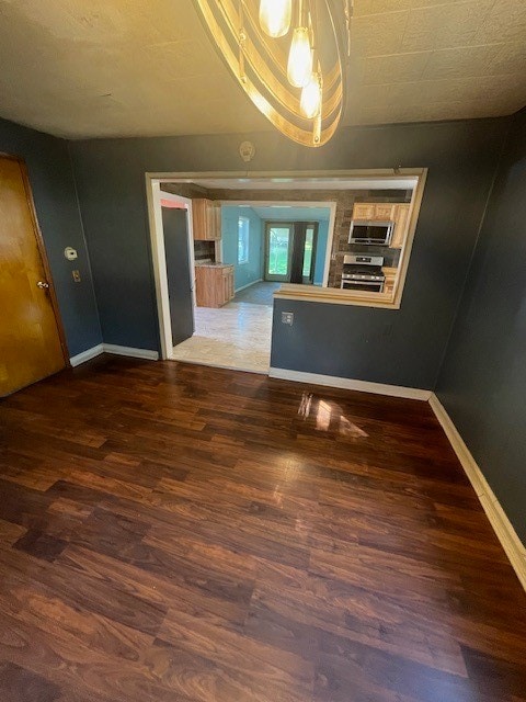 unfurnished dining area featuring dark wood-type flooring