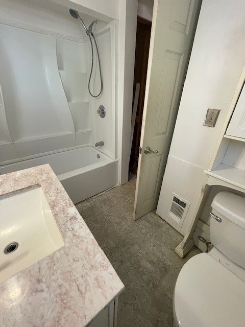 full bathroom featuring tub / shower combination, vanity, and toilet