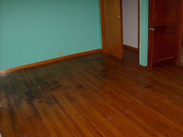 unfurnished bedroom featuring dark wood-type flooring and a closet