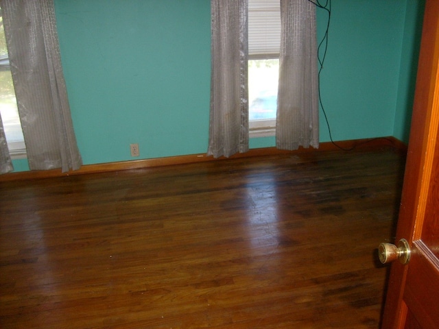 unfurnished room with dark wood-type flooring