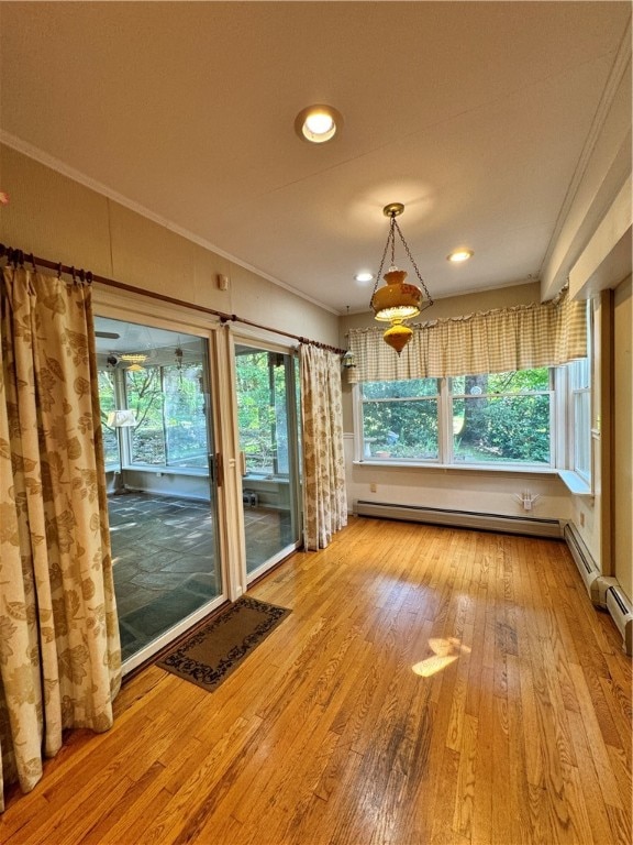 interior space featuring a baseboard heating unit, light wood-type flooring, and ornamental molding