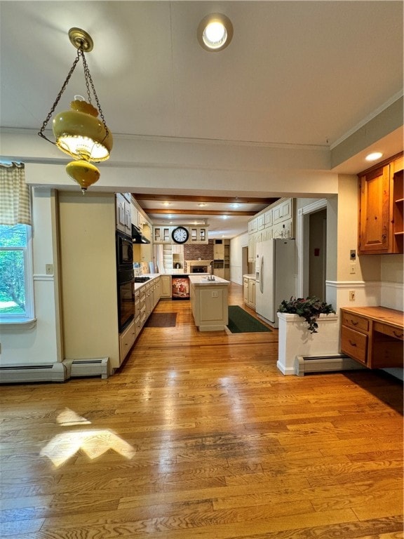 kitchen featuring a kitchen island, white fridge with ice dispenser, a baseboard radiator, and light hardwood / wood-style flooring