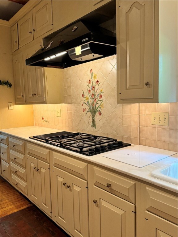 kitchen with backsplash, dark hardwood / wood-style flooring, and gas cooktop