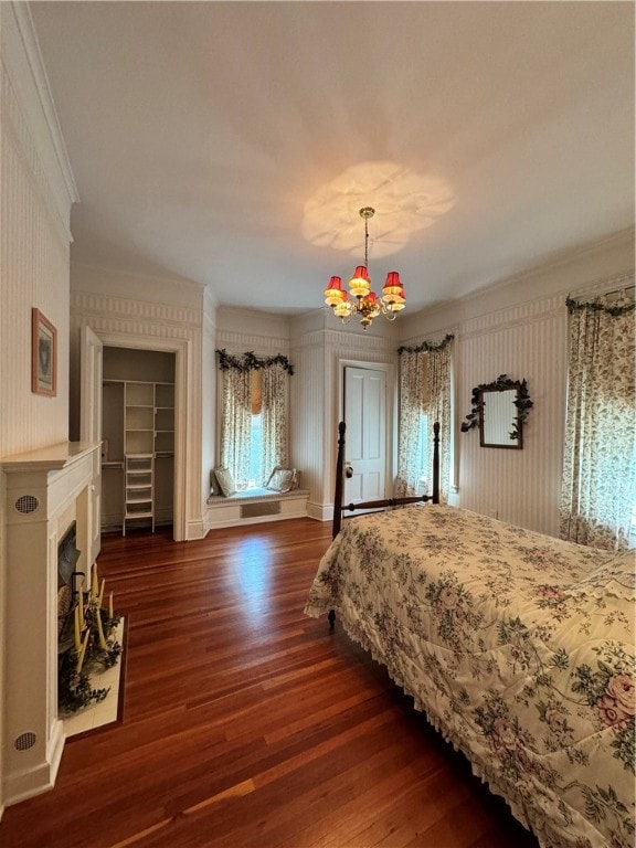 bedroom with a notable chandelier, dark hardwood / wood-style floors, and crown molding