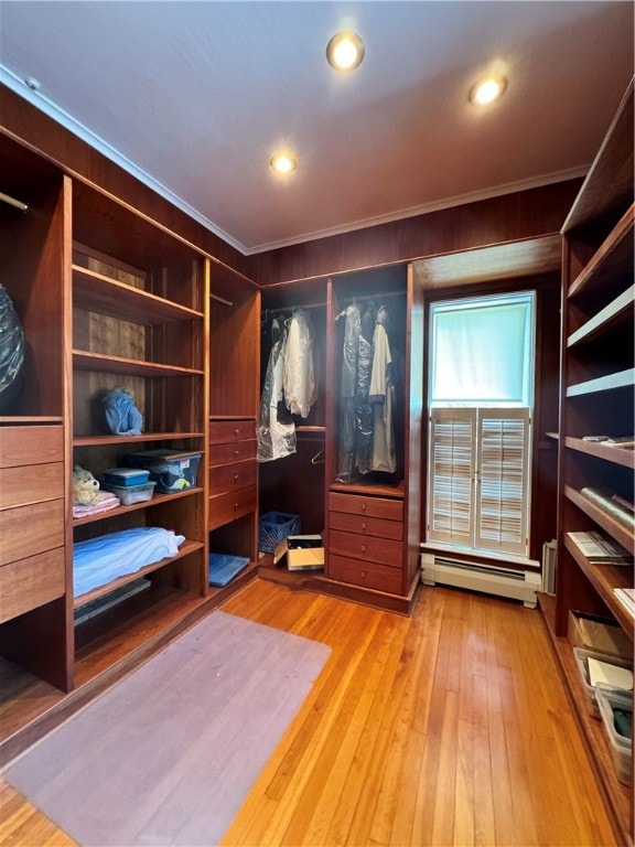 walk in closet featuring light hardwood / wood-style flooring and a baseboard heating unit