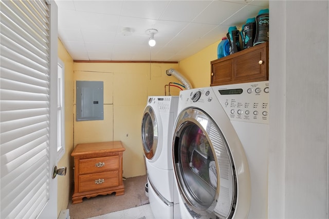 laundry area featuring electric panel, washing machine and clothes dryer, and cabinets