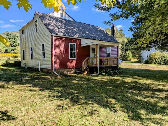 rear view of property featuring a lawn