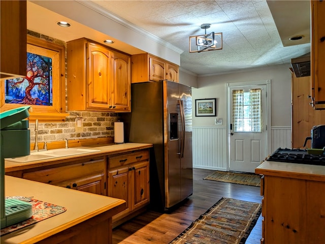 kitchen featuring dark hardwood / wood-style floors, an inviting chandelier, stainless steel refrigerator with ice dispenser, ornamental molding, and sink