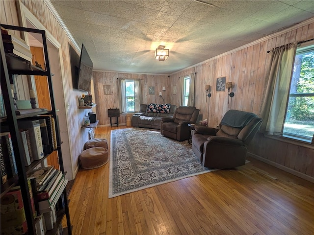 living room with crown molding, hardwood / wood-style floors, and wooden walls