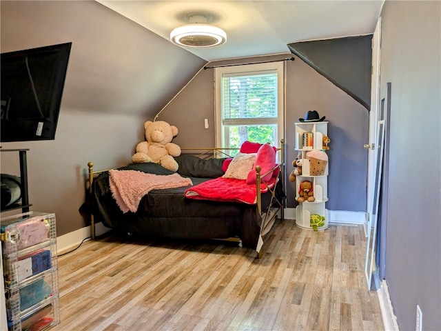 bedroom with lofted ceiling and light hardwood / wood-style flooring