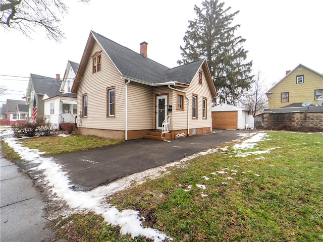 view of front facade featuring an outdoor structure, a garage, and a front lawn