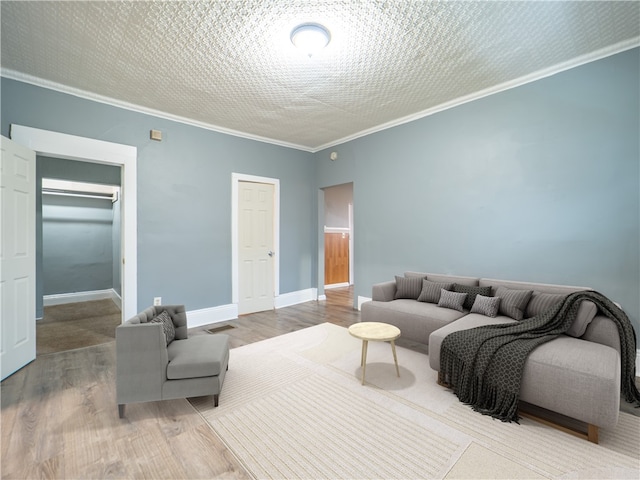 living room featuring wood-type flooring, a textured ceiling, and ornamental molding