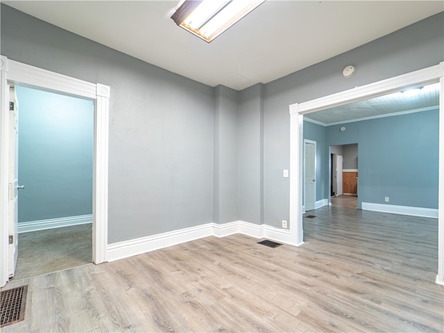 unfurnished room featuring crown molding and hardwood / wood-style floors