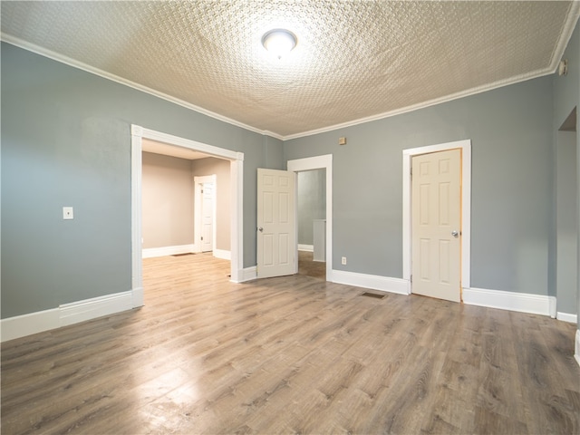 unfurnished bedroom featuring a textured ceiling, crown molding, and wood-type flooring