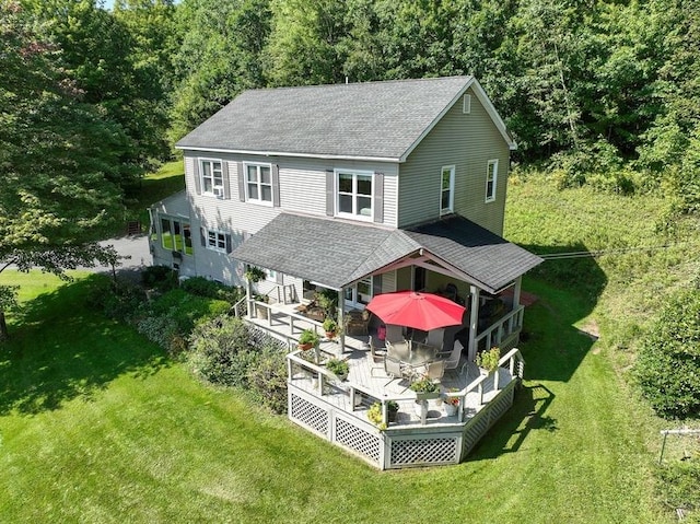 back of property with a wooden deck and a yard